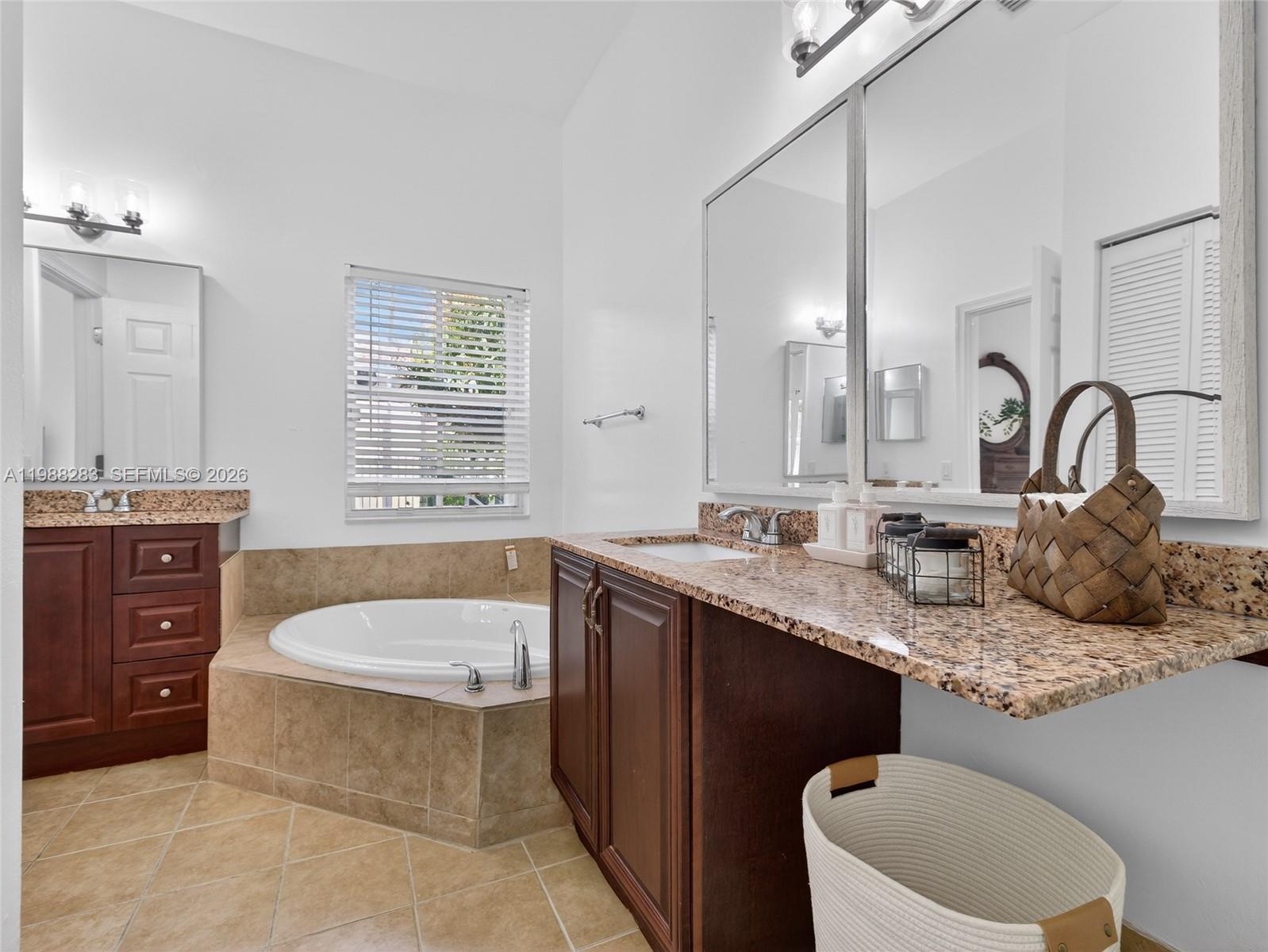 4317 Willow Ridge Drive Weston, FL 33331 - Photo 22 of 71 a bathroom with a granite countertop tub a double vanity sink and a mirror