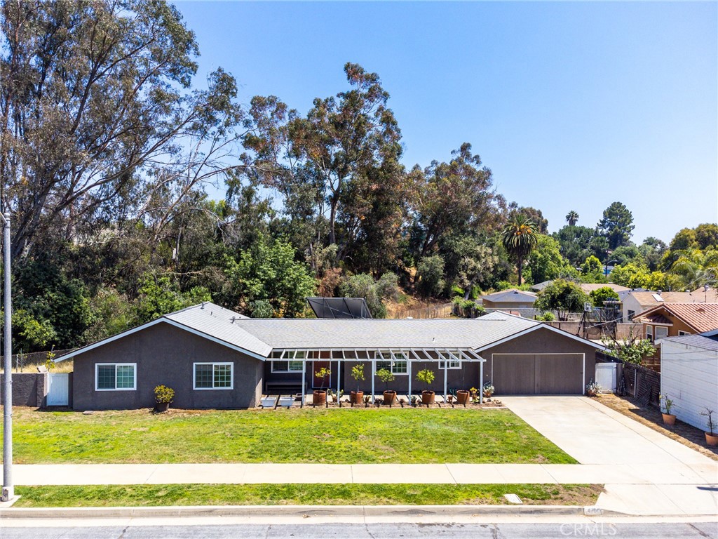 a view of a house with a big yard and large trees