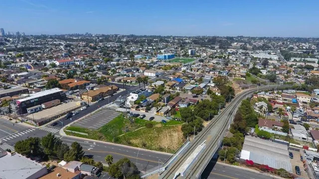 an aerial view of residential houses with outdoor space and trees
