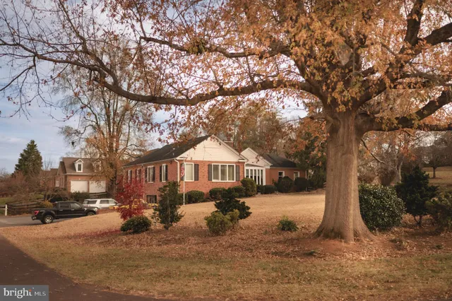 a front view of a house with a yard covered in snow