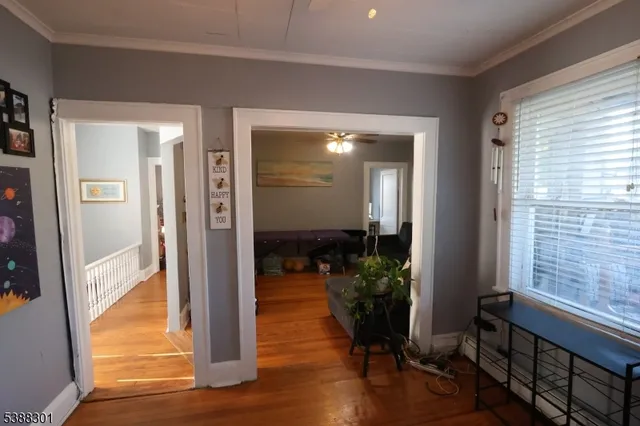 a view of a hallway with wooden floor windows and a livingroom