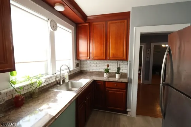 a kitchen with granite countertop a sink stainless steel appliances and a window