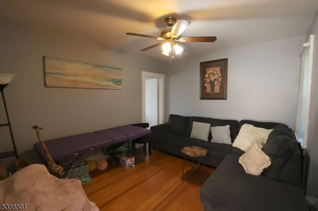 a living room with furniture and a ceiling fan