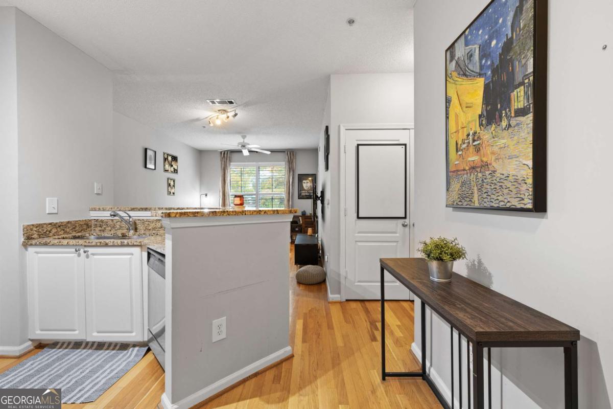 10 Perimeter Summit Boulevard Brookhaven, GA 30319 - Photo 8 of 20 a kitchen with stainless steel appliances granite countertop a refrigerator a stove and a dining table with wooden floor