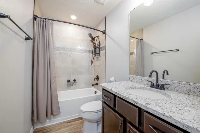 a bathroom with a granite countertop sink toilet and shower