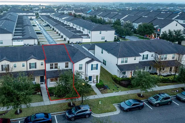 front view of house with a yard and large trees