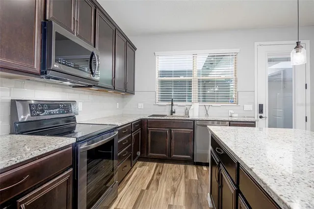 a kitchen with stainless steel appliances granite countertop stove microwave and sink