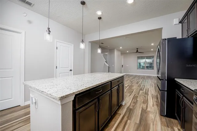a kitchen with a center island wooden floor appliances and a window