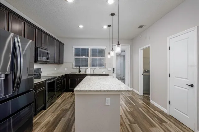 a kitchen with a refrigerator a sink and cabinets