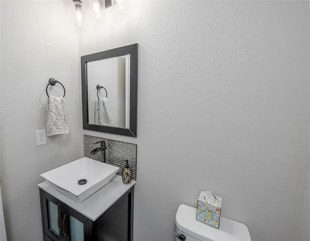 a bathroom with a toilet sink vanity and mirror
