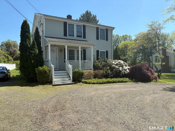 a view of a house with a yard and potted plants