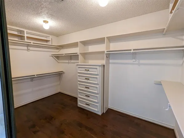 an empty room with wooden floor chandelier and windows