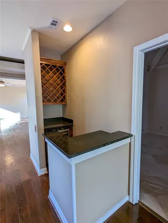 a kitchen with granite countertop a stove and a wooden floor