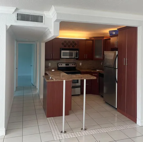 a kitchen with stainless steel appliances granite countertop a refrigerator and a sink