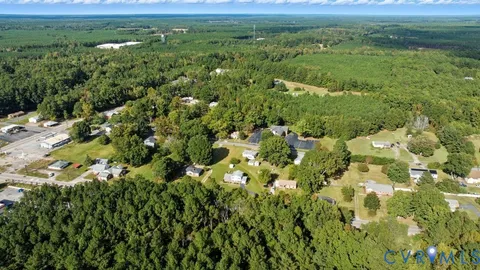 an aerial view of residential house with outdoor space and trees all around