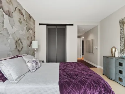 a bedroom with a bed and a flat tv screen on the dresser