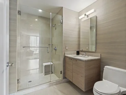 a bathroom with a granite countertop sink toilet and shower