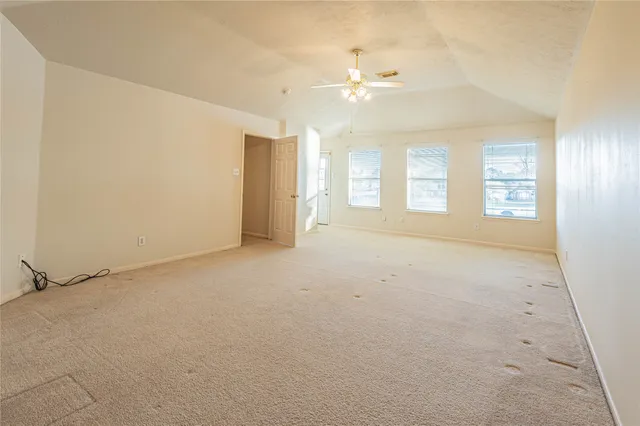 an empty room with windows and fan