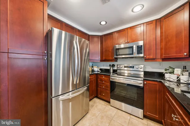 a kitchen with stainless steel appliances granite countertop a refrigerator stove microwave and sink
