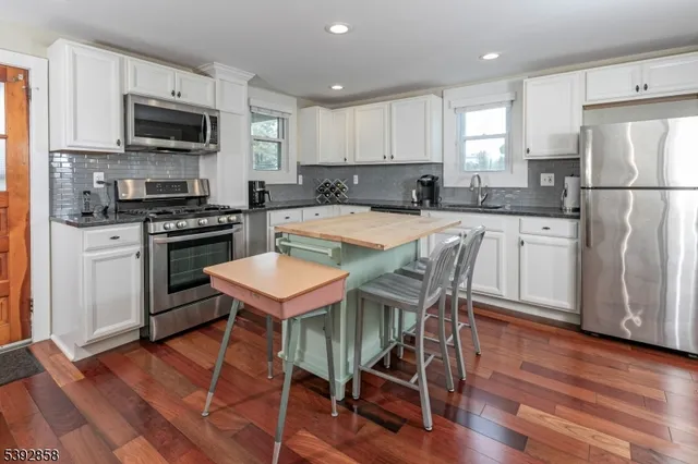 a kitchen with white cabinets and stainless steel appliances