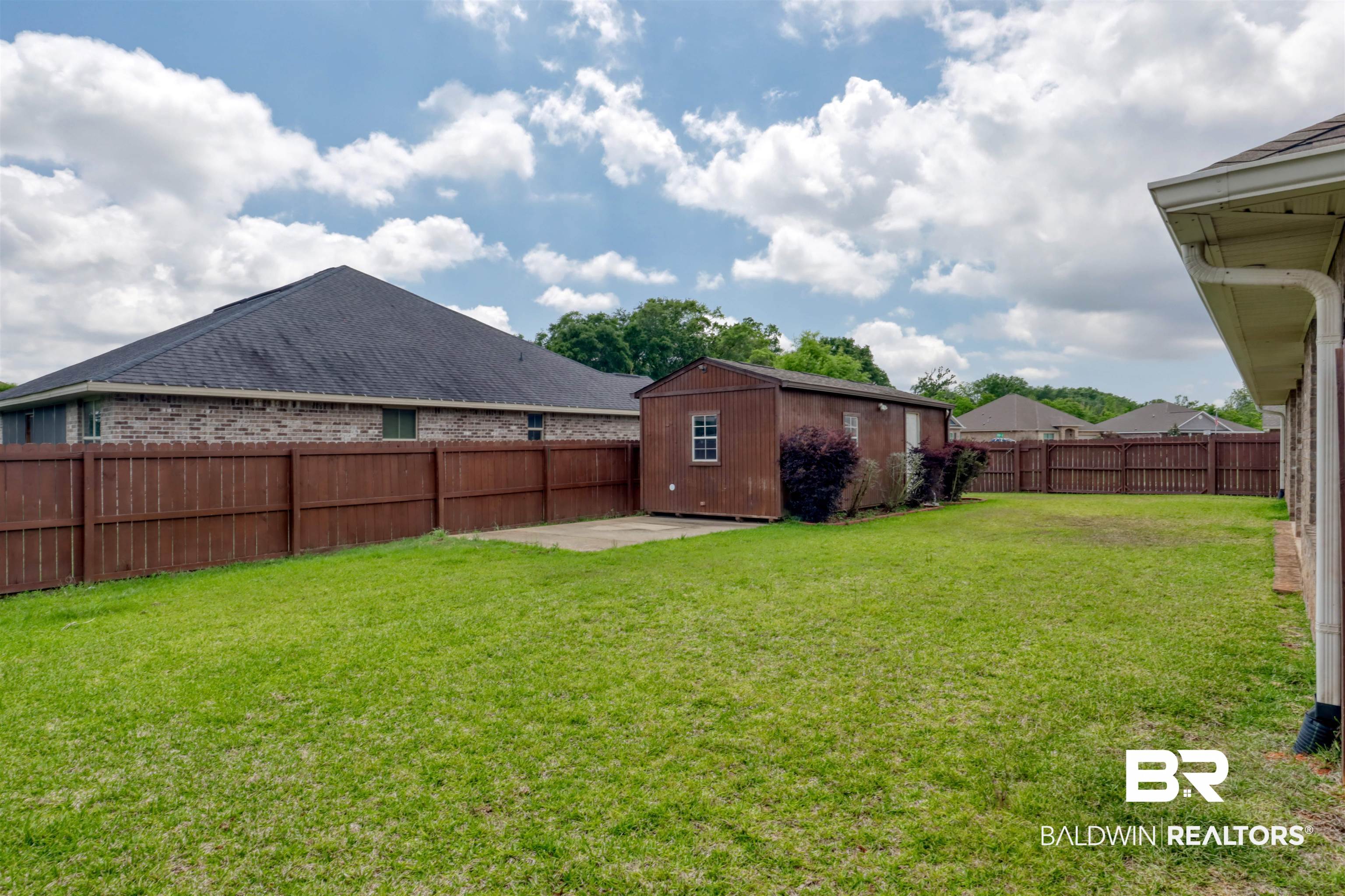 14794 Troon Drive Foley, AL 36535 - Photo 28 of 33 View of yard featuring an outbuilding, a fenced backyard, and a patio area