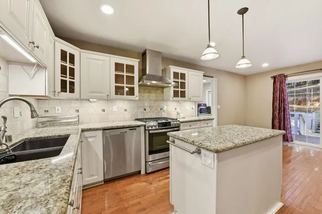 a kitchen with stainless steel appliances granite countertop a sink stove and refrigerator