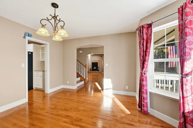 a view of a room with wooden floor and a chandelier
