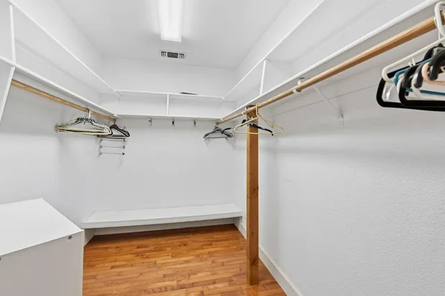 a view of walk in closet with clothes and shoes