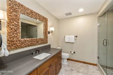 a bathroom with a sink and a mirror with toilet