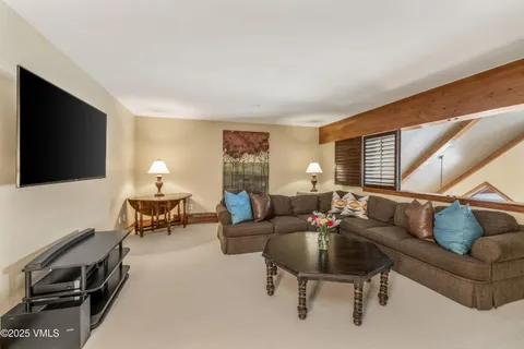 a living room with furniture a flat screen tv and a window
