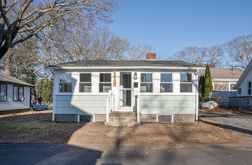 a front view of a house with a yard and seating space