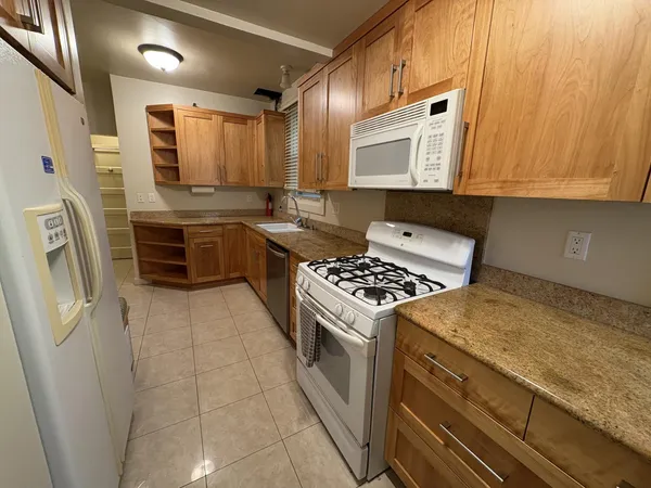 a kitchen with stainless steel appliances granite countertop a stove a sink and a microwave