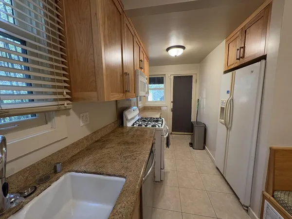 a kitchen with stainless steel appliances granite countertop a refrigerator and a sink