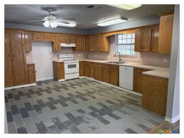 a large kitchen with stainless steel appliances granite countertop a sink dishwasher stove and refrigerator