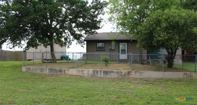 a backyard of a house with wooden floor and fence