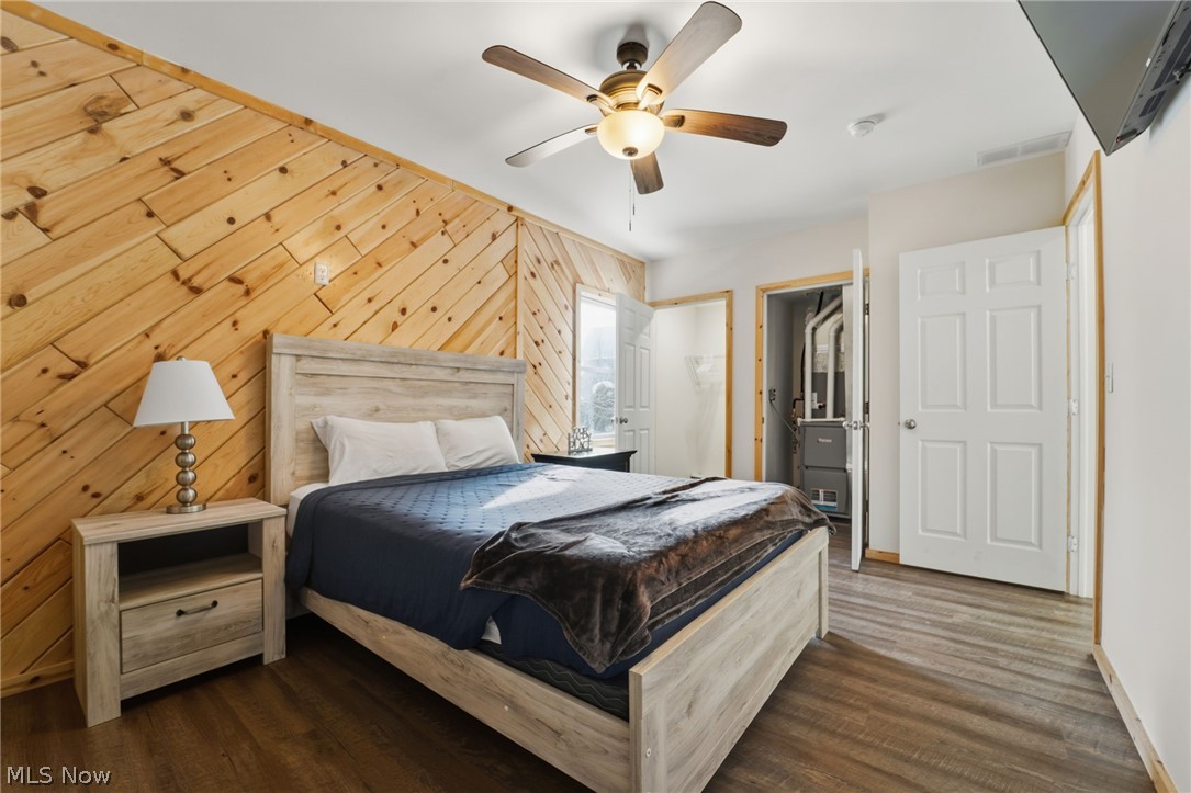 5919 Lake Road West, Unit 32 Ashtabula, OH 44004 - Photo 12 of 23 Bedroom with a ceiling fan, dark wood-type flooring, and wooden walls