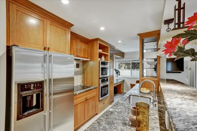 a kitchen with stainless steel appliances granite countertop a refrigerator and a stove