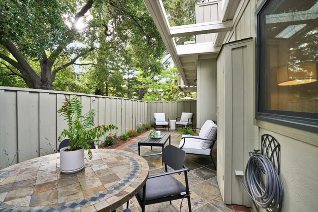 a view of a patio with chairs and potted plants