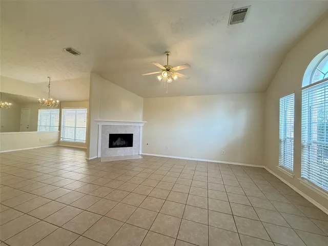 an empty room with windows and a ceiling fan