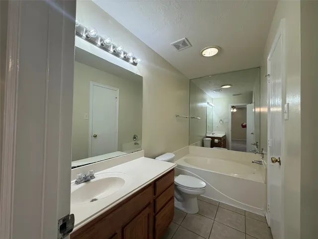 a spacious bathroom with a granite countertop sink a toilet and shower
