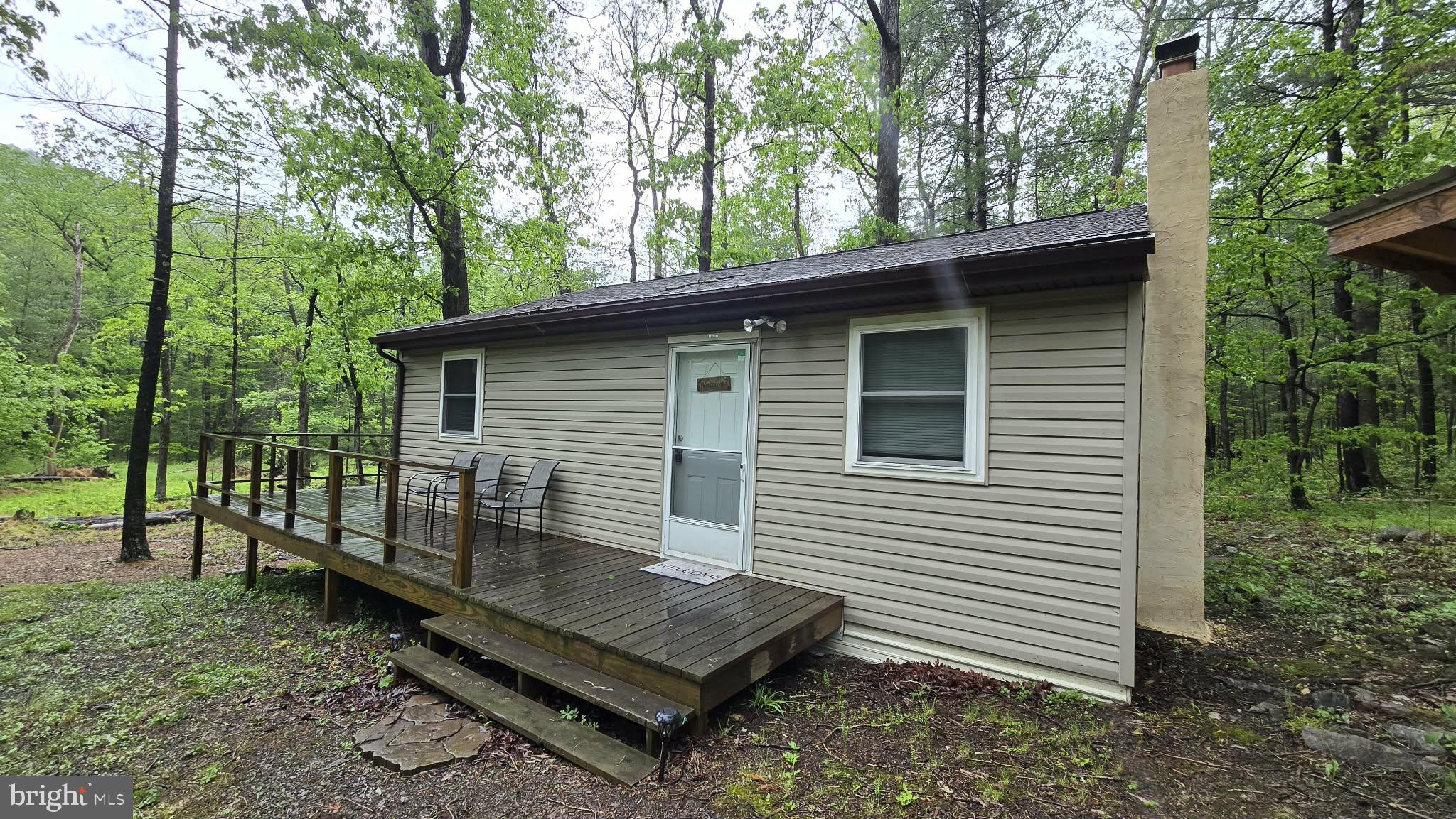 8245 Aughwick Road Fort Loudon, PA 17224 - Photo 21 of 26 a view of a wooden deck with a bench and trees