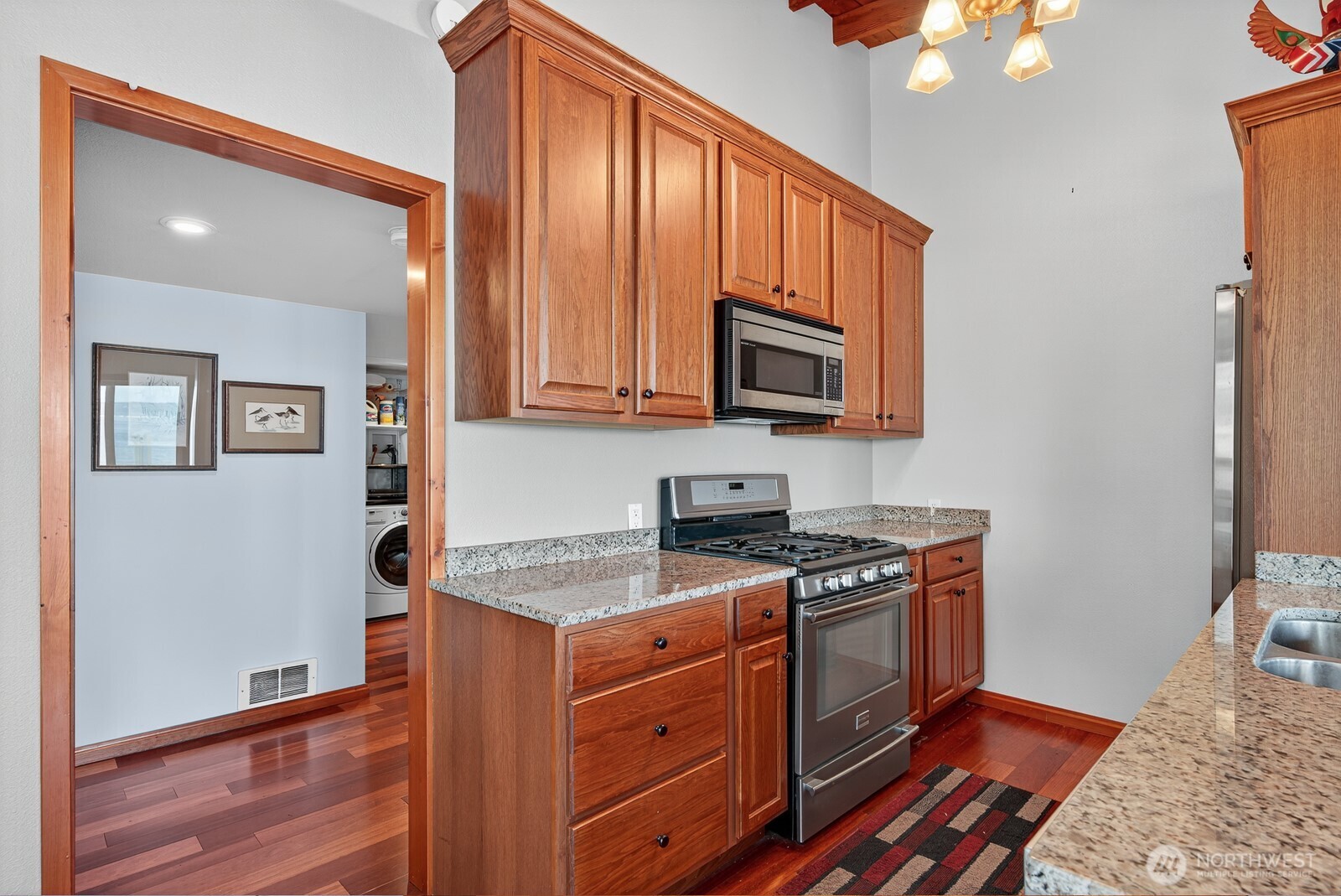 19422 Soundview Drive Northwest Stanwood, WA 98292 - Photo 13 of 33 a kitchen with stainless steel appliances granite countertop a stove a sink and a microwave