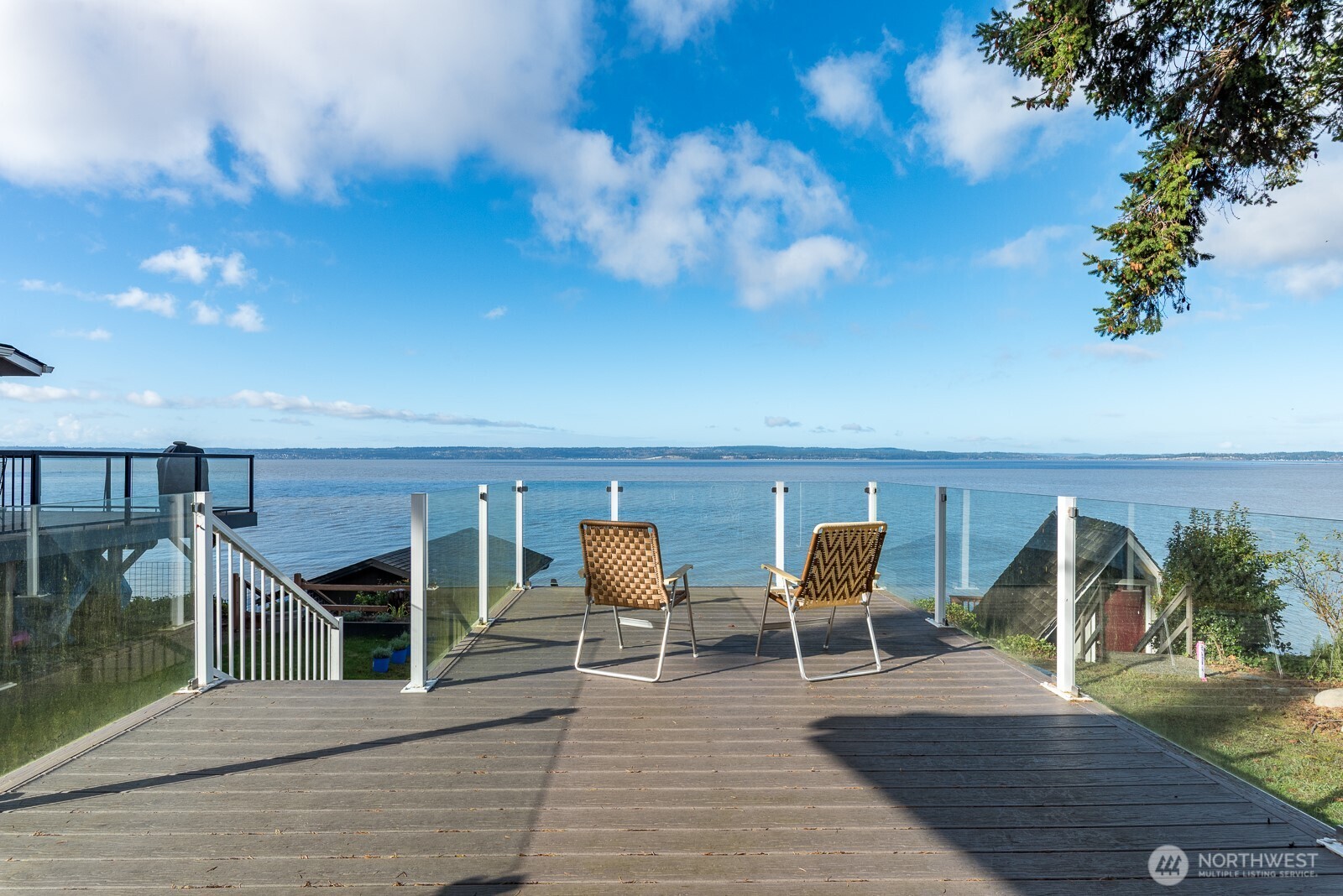 19422 Soundview Drive Northwest Stanwood, WA 98292 - Photo 23 of 33 a view of a balcony with chairs potted plants with wooden floor and fence