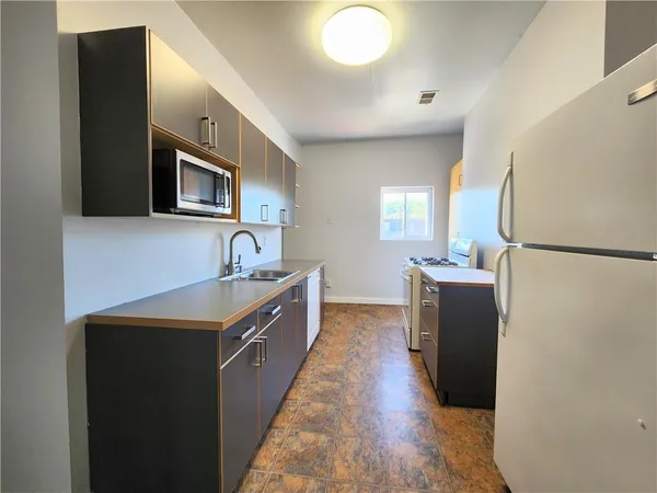 a kitchen with sink cabinets and refrigerator