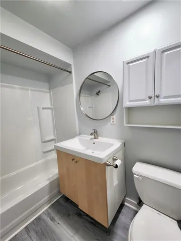 a bathroom with a toilet a sink and mirror