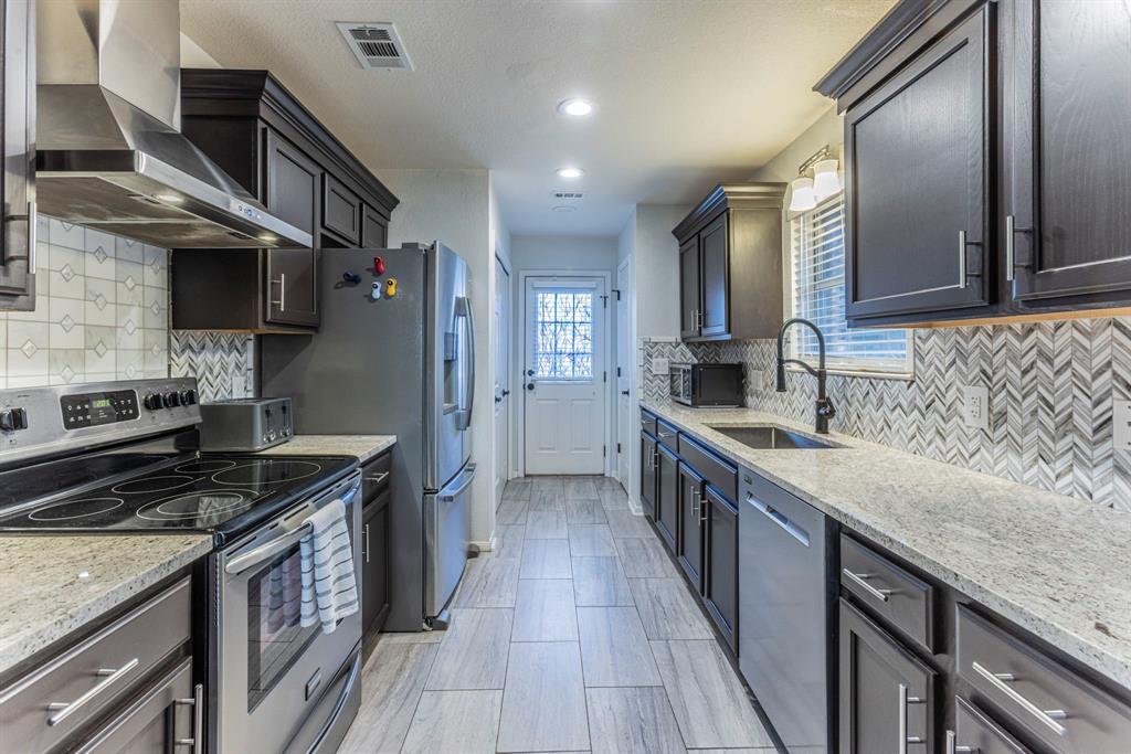 1202 Spring Street Waco, TX 76704 - Photo 5 of 16 a kitchen with stainless steel appliances granite countertop a stove and a sink