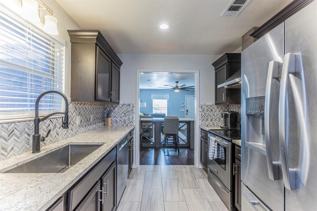 1202 Spring Street Waco, TX 76704 - Photo 6 of 16 a kitchen with stainless steel appliances granite countertop a sink stove and refrigerator