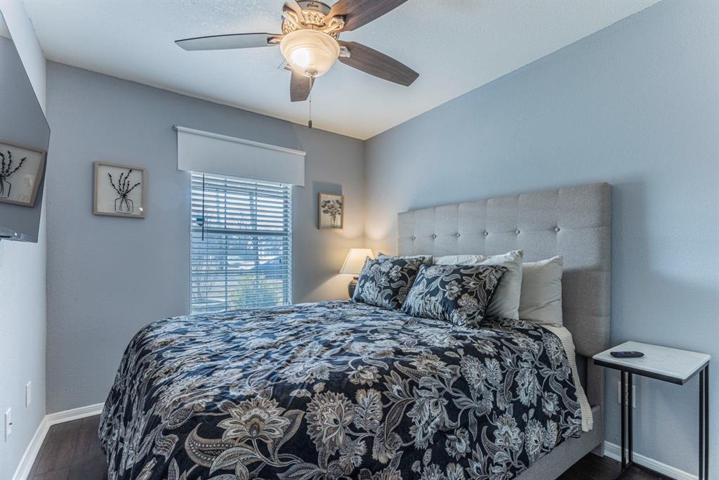 1202 Spring Street Waco, TX 76704 - Photo 10 of 16 a bed sitting in a bedroom next to a window and a chandelier