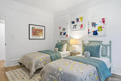 a bedroom with two beds and a painting on the wall