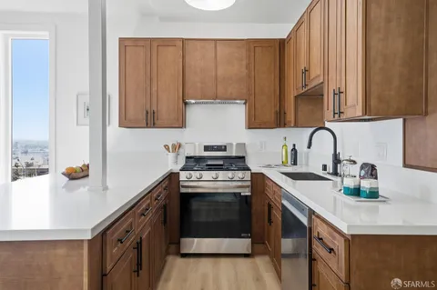 a kitchen with stainless steel appliances granite countertop a sink stove and cabinets